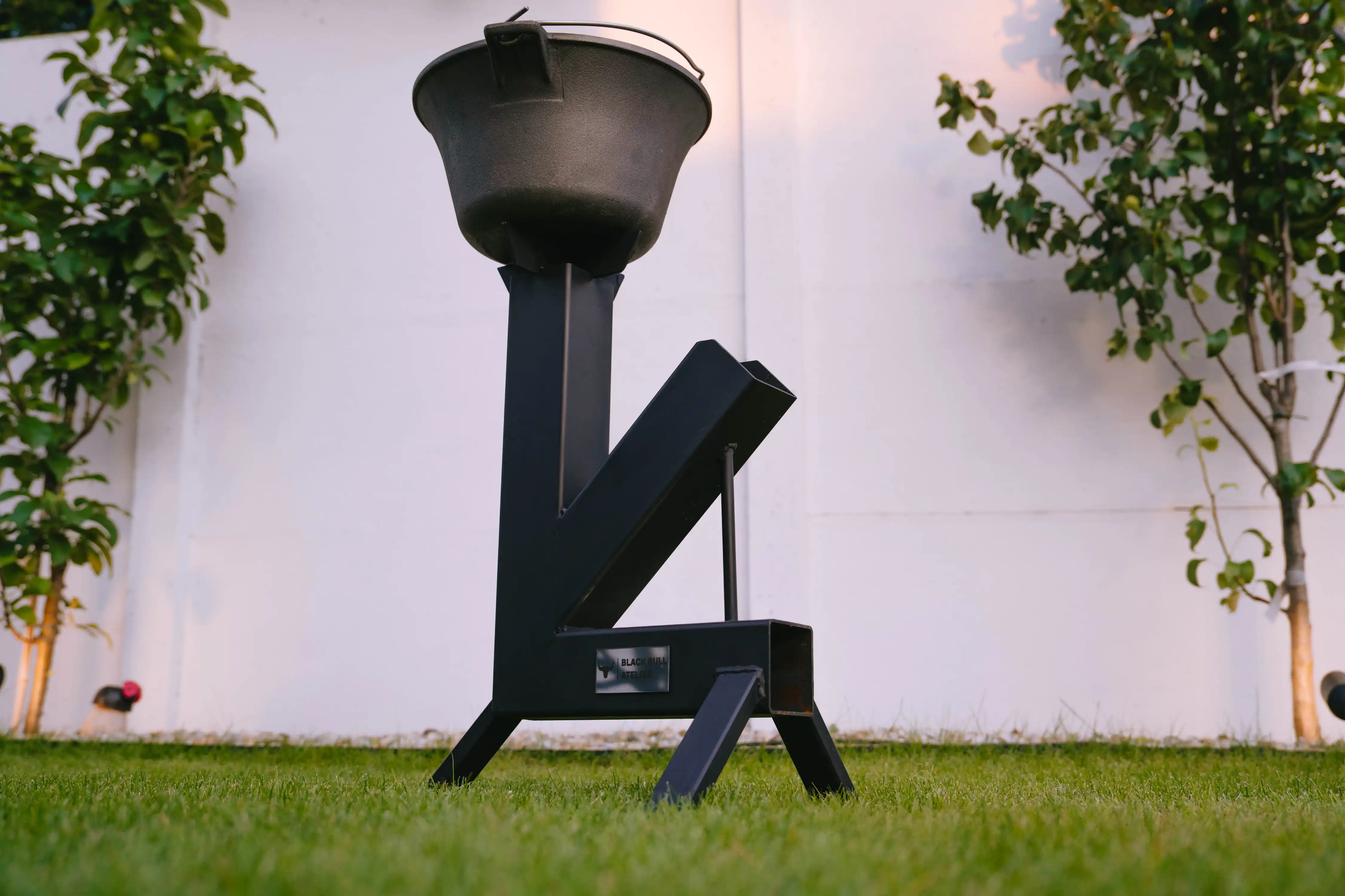 Matt black steel rocket grill, standing in the garden.