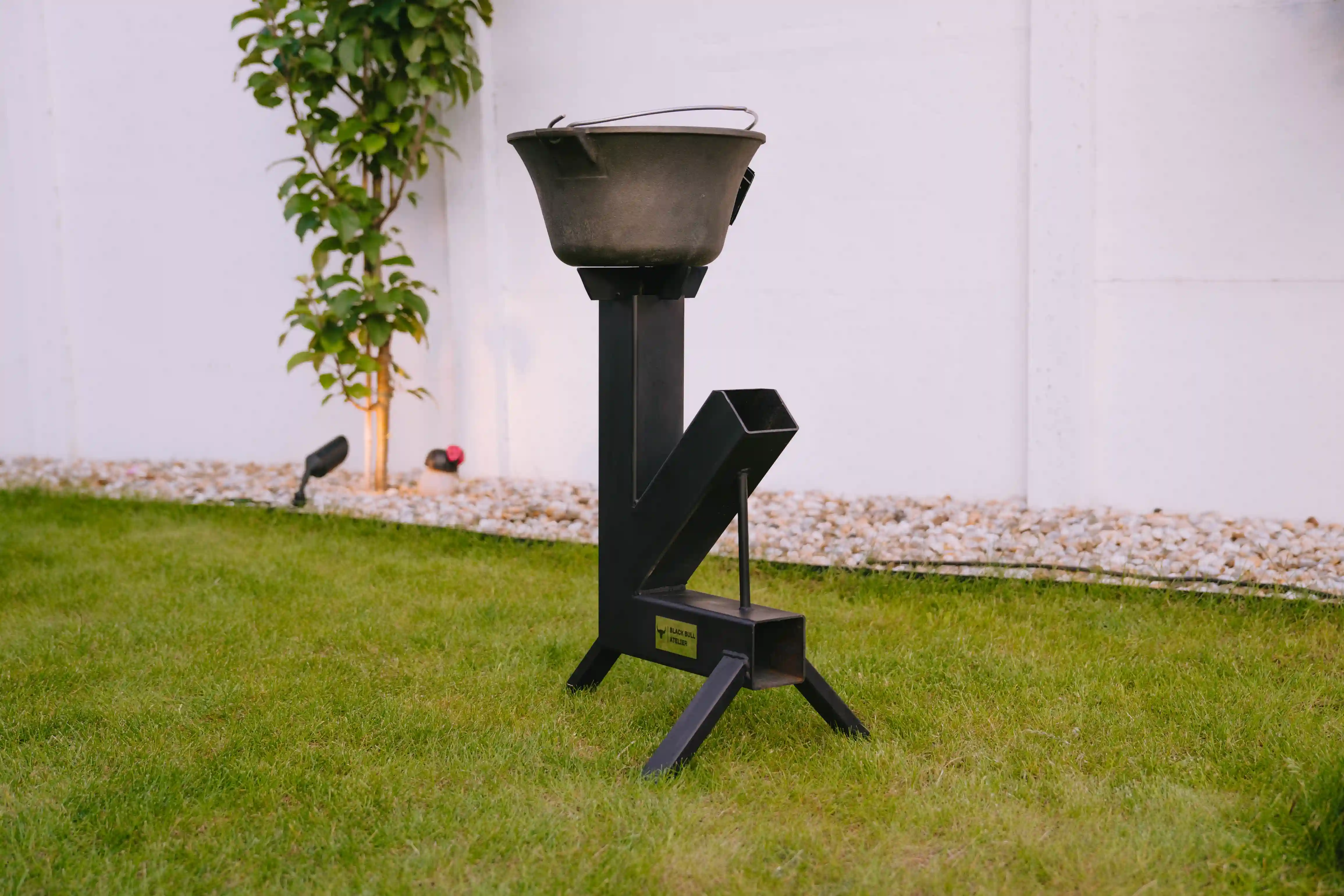 Matt black steel rocket grill, standing in the garden.