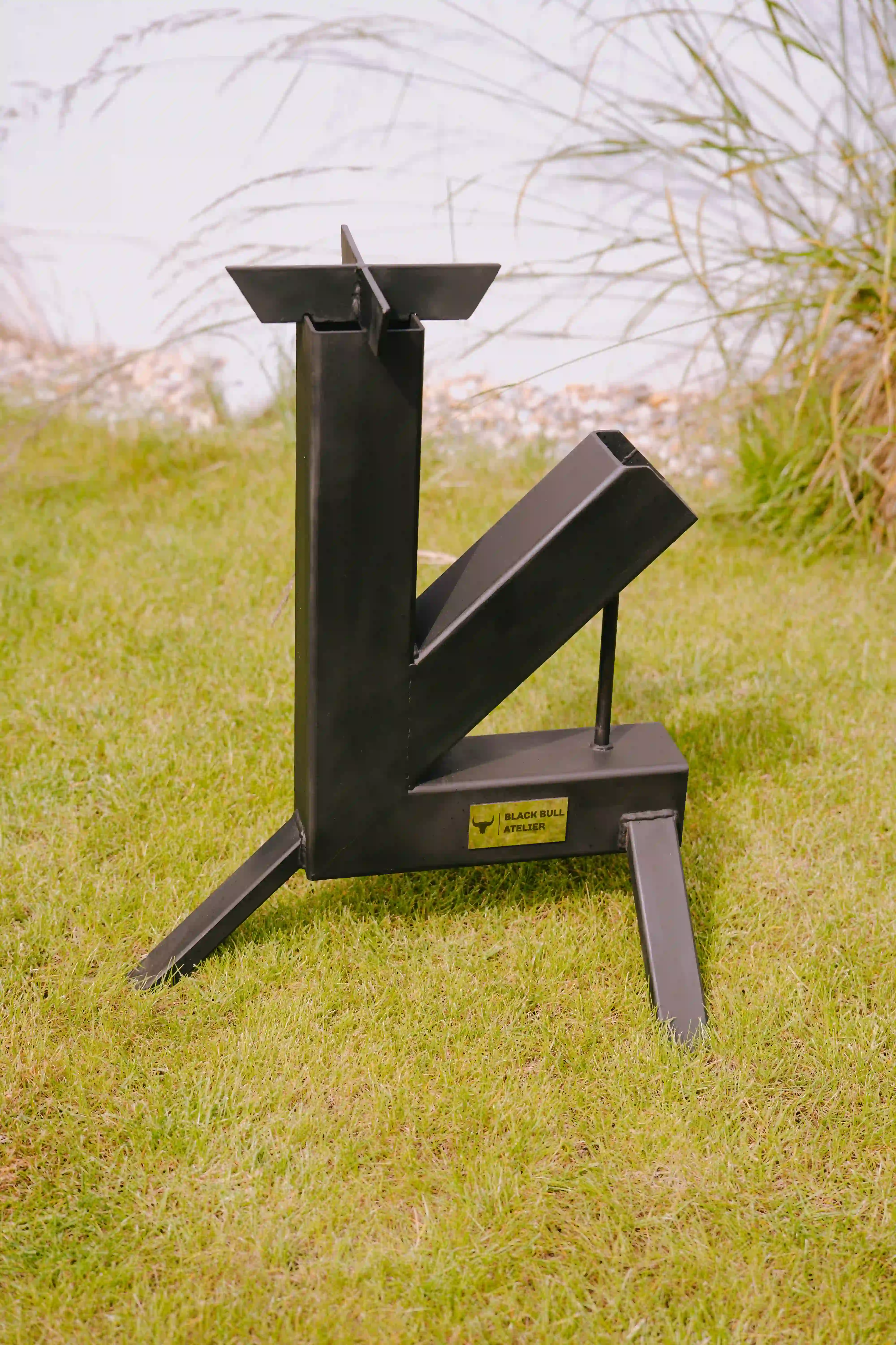 Matt black steel rocket grill, standing in the garden.